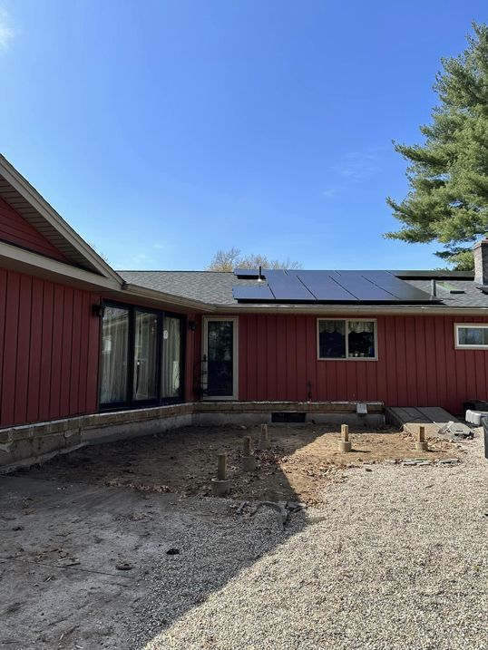 A red house with solar panels on the roof.