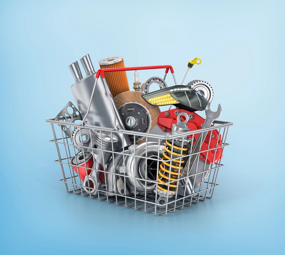 Una cesta de compra llena de piezas de automóvil sobre un fondo azul.