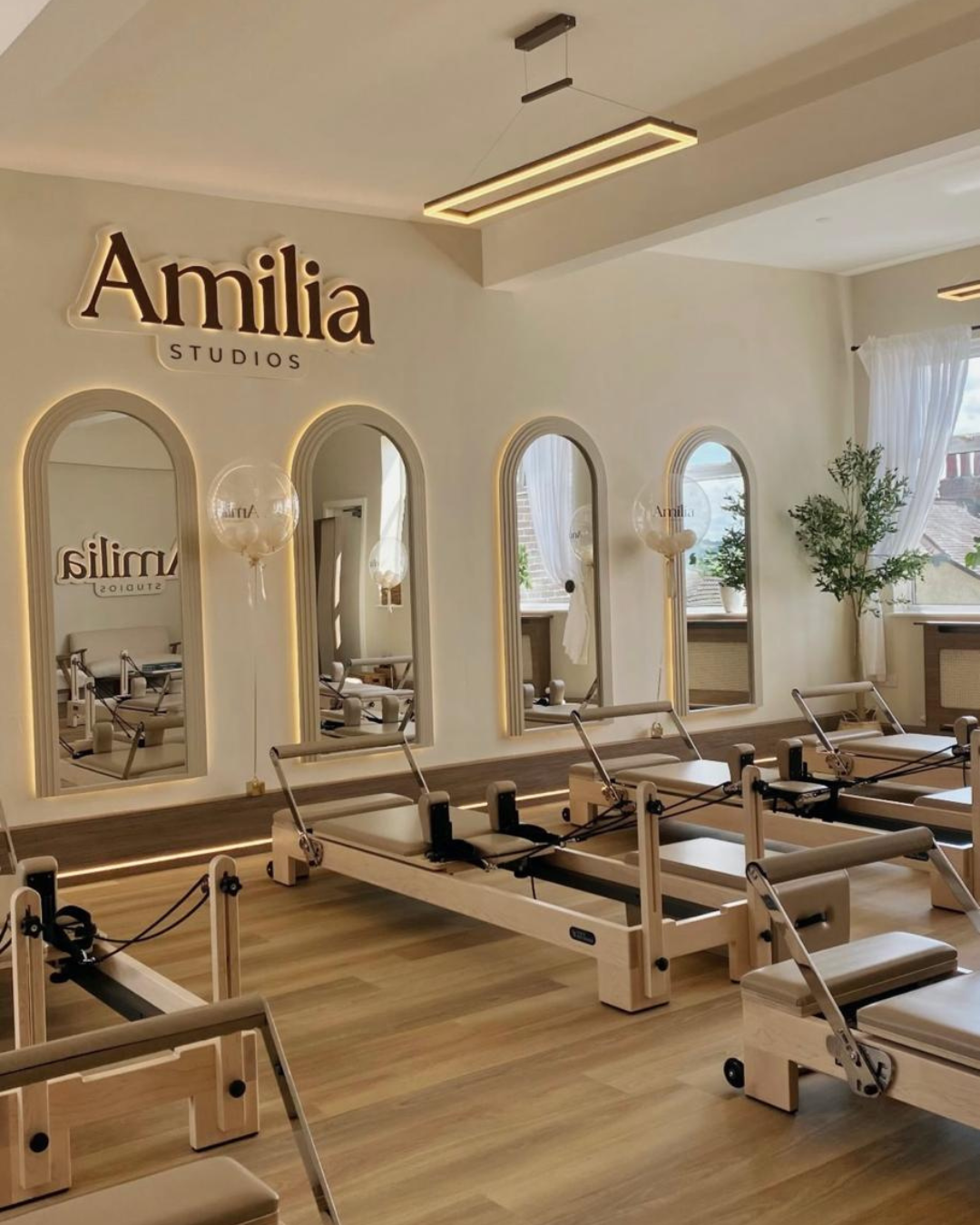 Amilia Studios reformer Pilates studio - image showing full room with arched mirrors and beige reformer beds