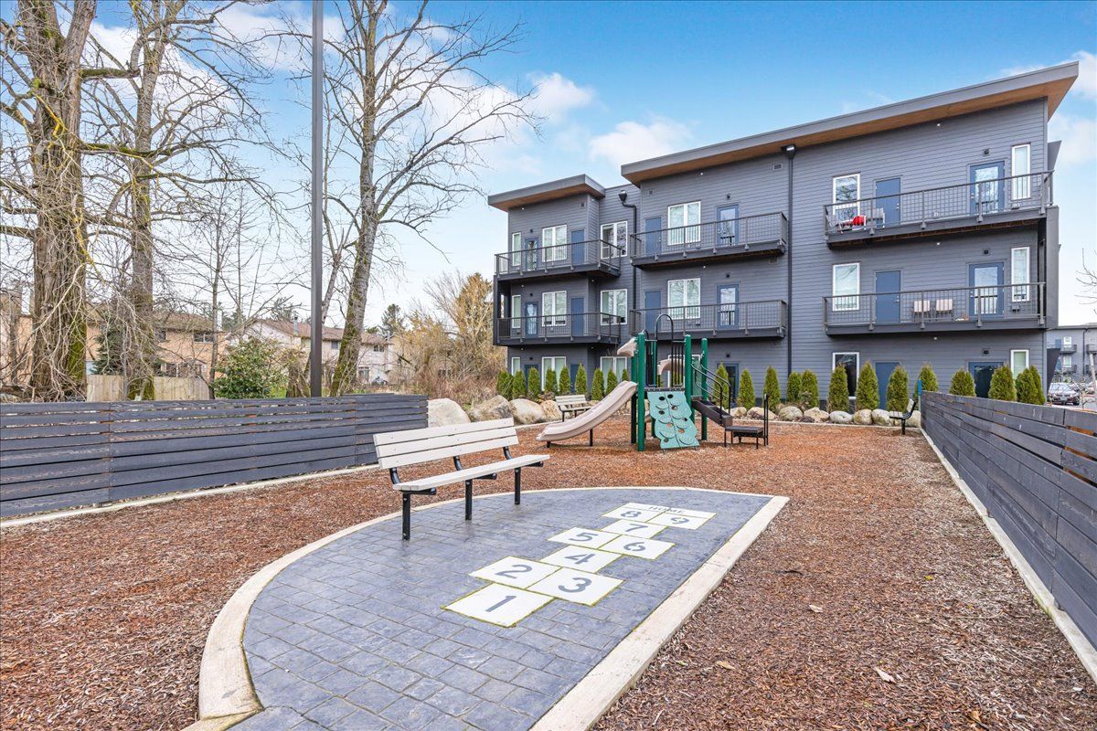 Exterior photo of apartment building with bench