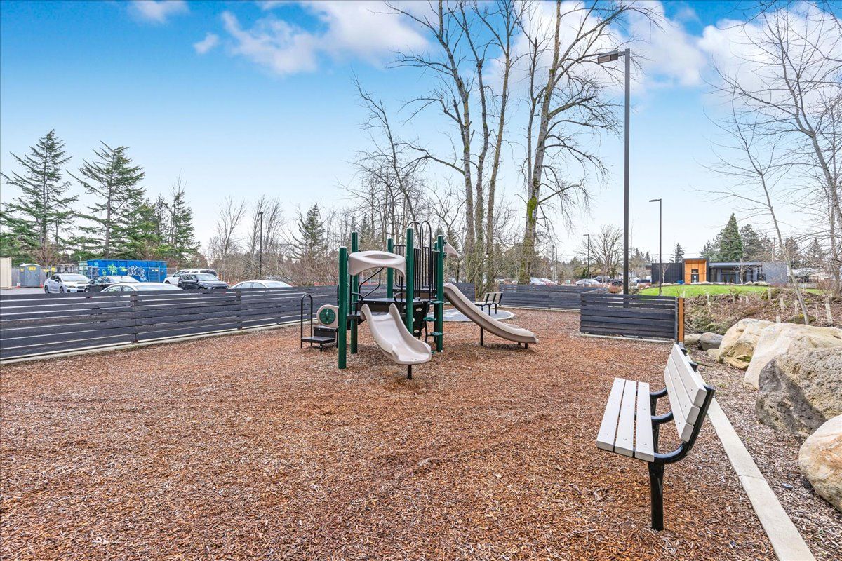 a playground with a slide and a bench in the middle of it .