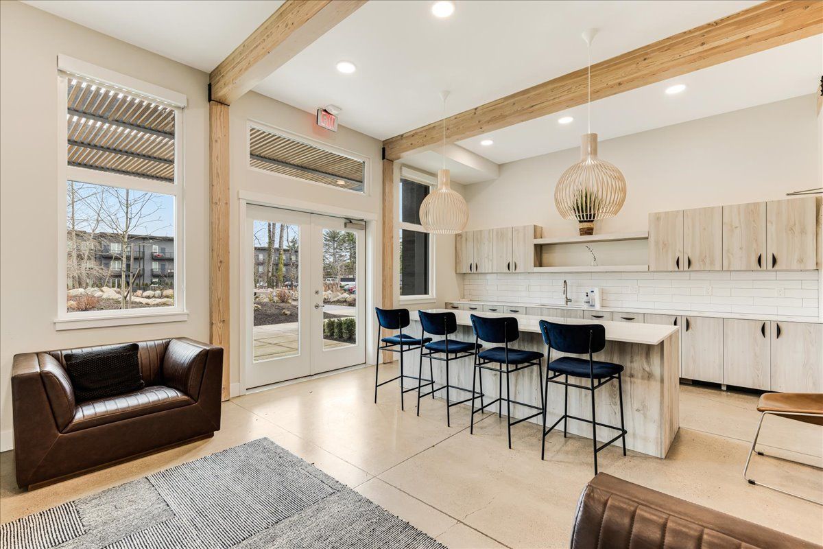 a living room with a couch , chairs , and a kitchen .