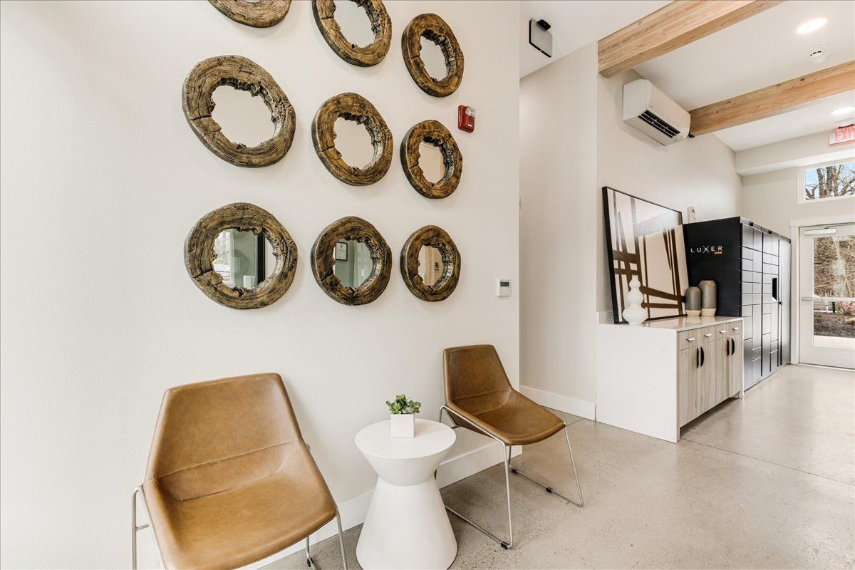 a waiting room with chairs and a table with mirrors on the wall .