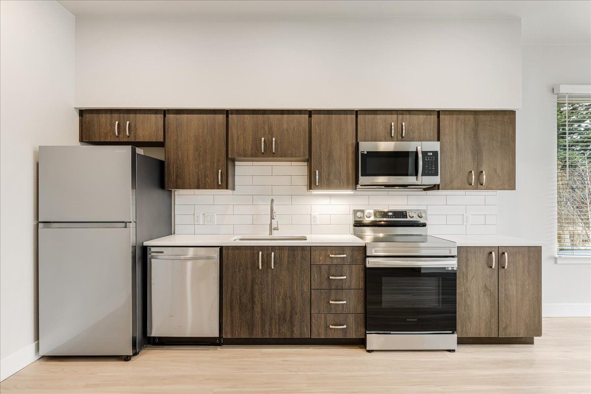 a kitchen with stainless steel appliances and wooden cabinets