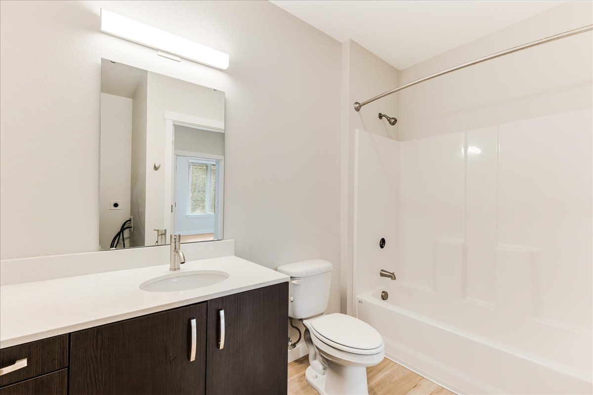 a bathroom with a sink , toilet , bathtub and mirror .