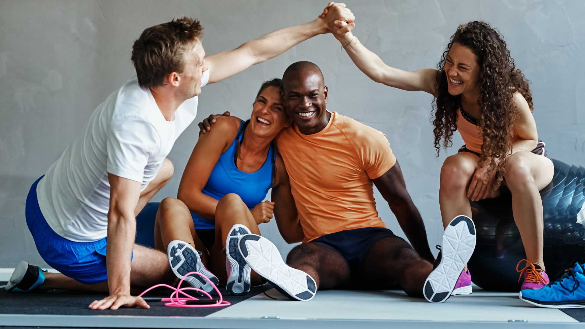 Een groep mensen geeft elkaar een high five in een sportschool.