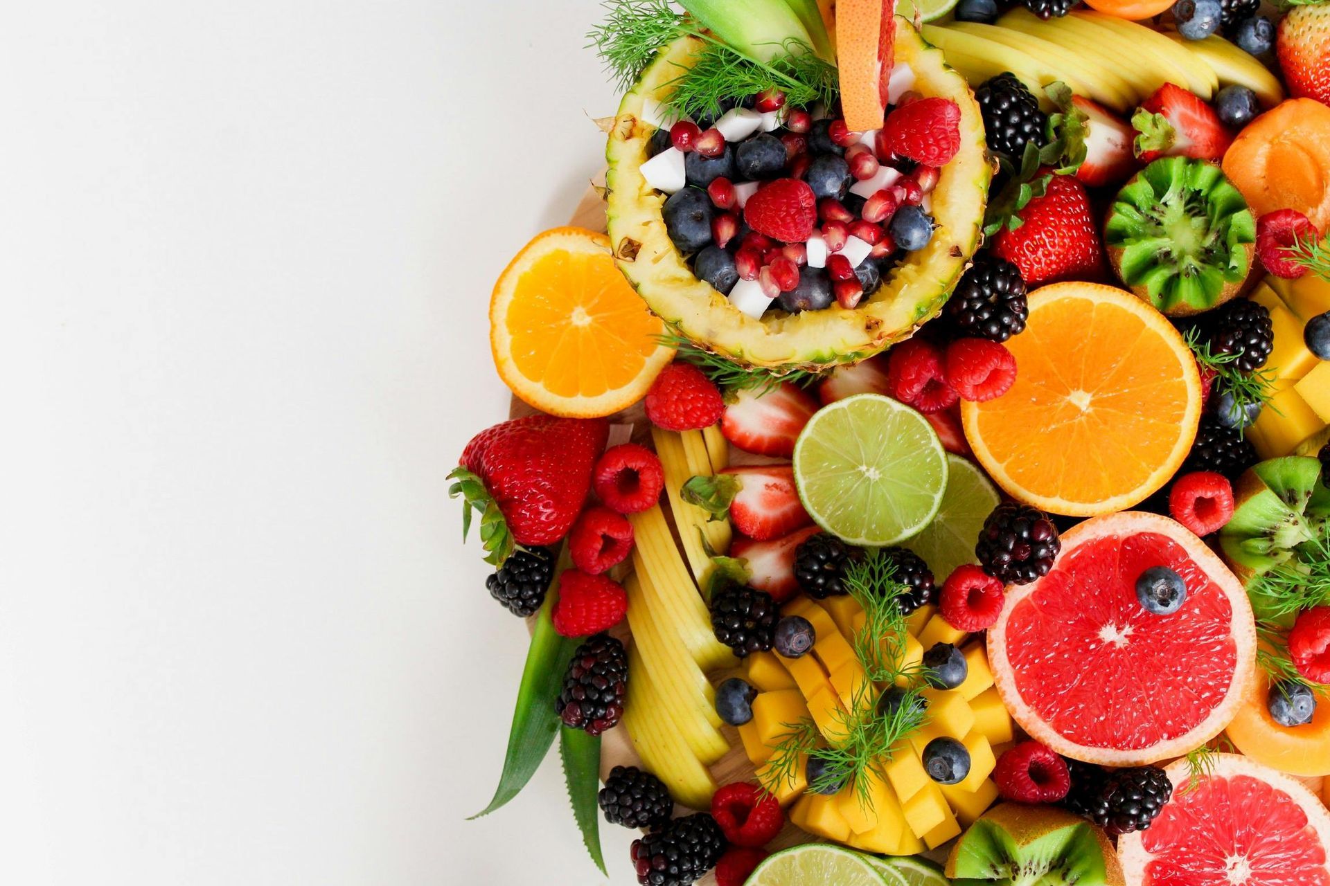Een wit bord gevuld met een verscheidenheid aan fruit en groenten.