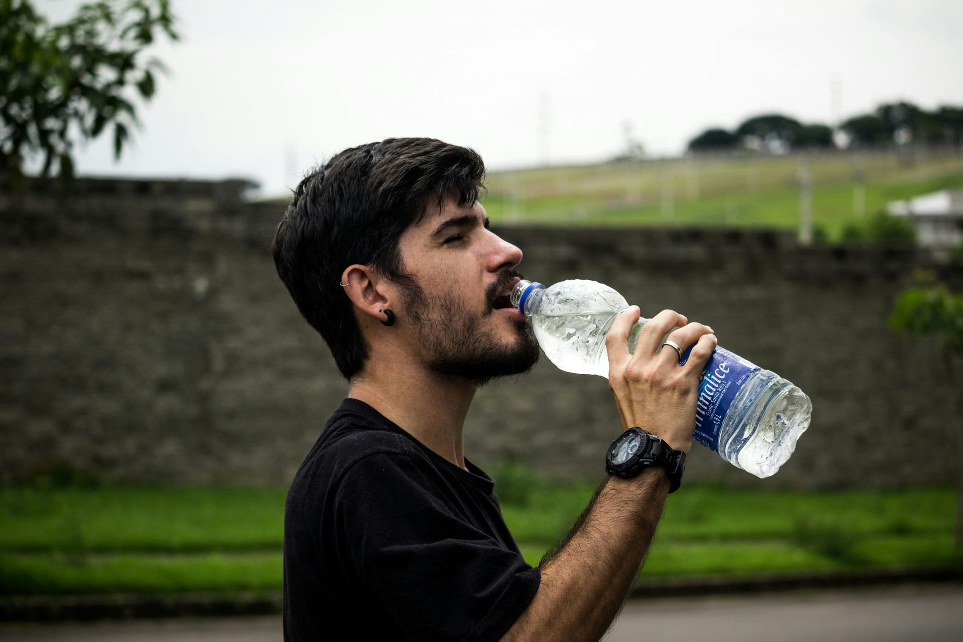Een man drinkt water uit een fles.