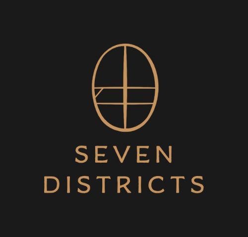 Seven Districts logo in gold on a black background, featuring a stylized oval emblem and text.