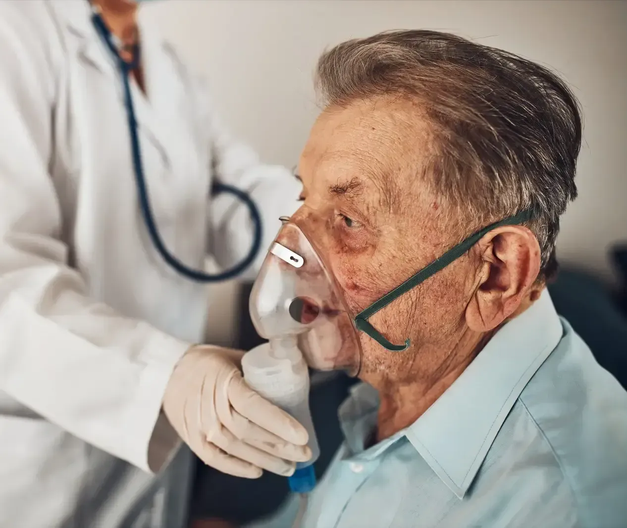 Healthcare worker helping a patient use an oxygen mask in a clinic