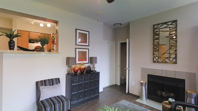 A living room with a fireplace , chairs and a dresser at Steeplechase Apartments.in Knoxville, Tennessee