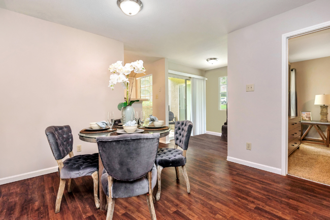 A dining room with a table and chairs and hardwood floors at Steeplechase Apartments in Knoxville, Tennessee