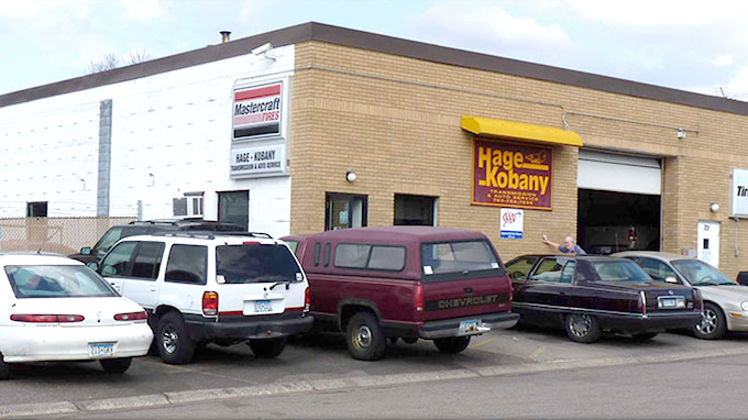 A row of cars are parked in front of a building that says wayne jobarry