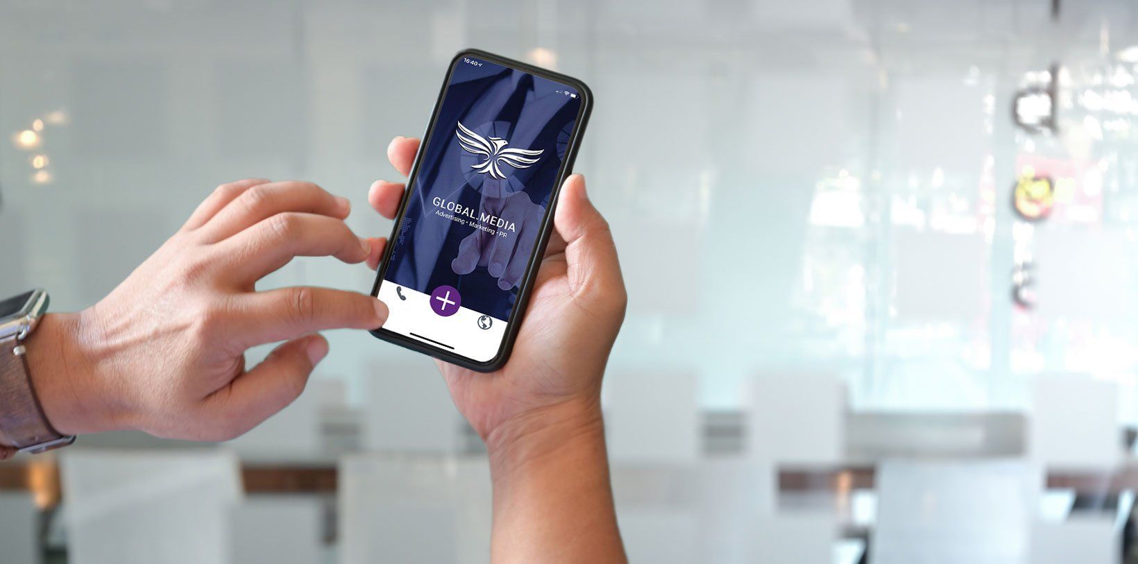 Person holding a smartphone with an app open, likely in an office setting.