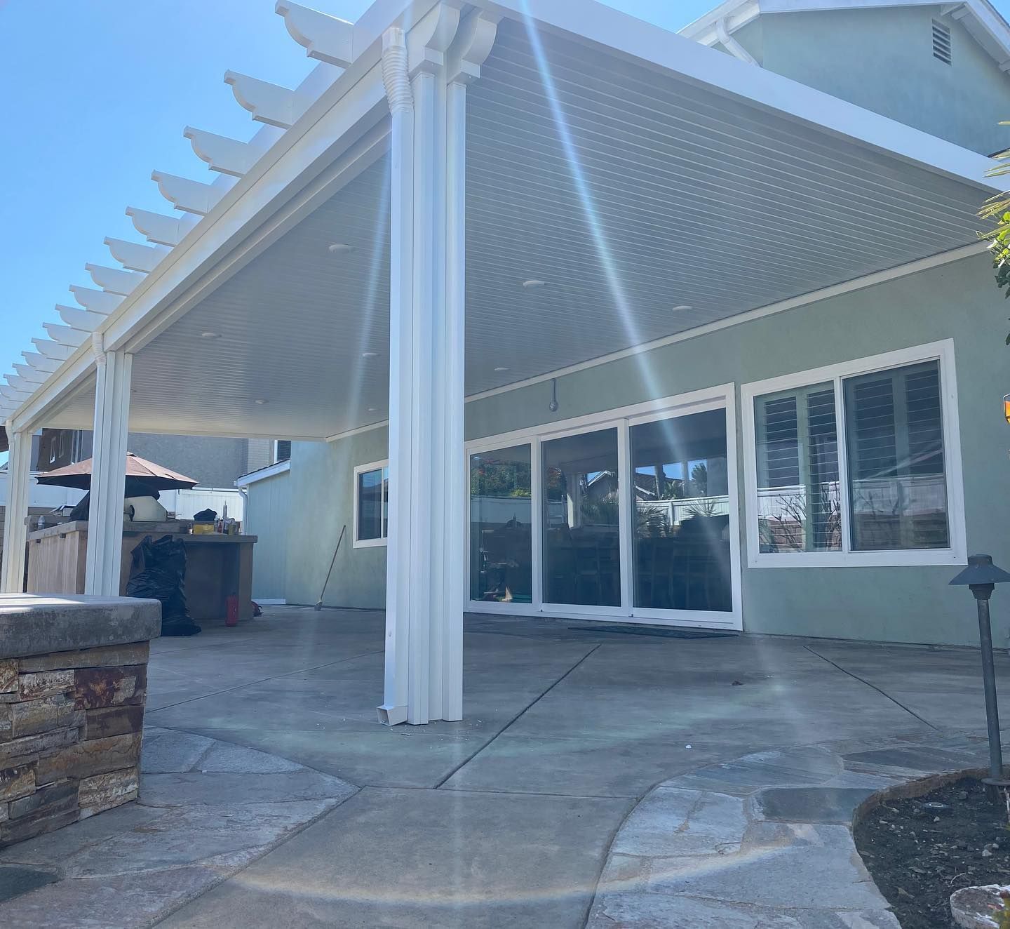 A living room with a couch , chairs , coffee table and sliding glass doors leading to a patio.