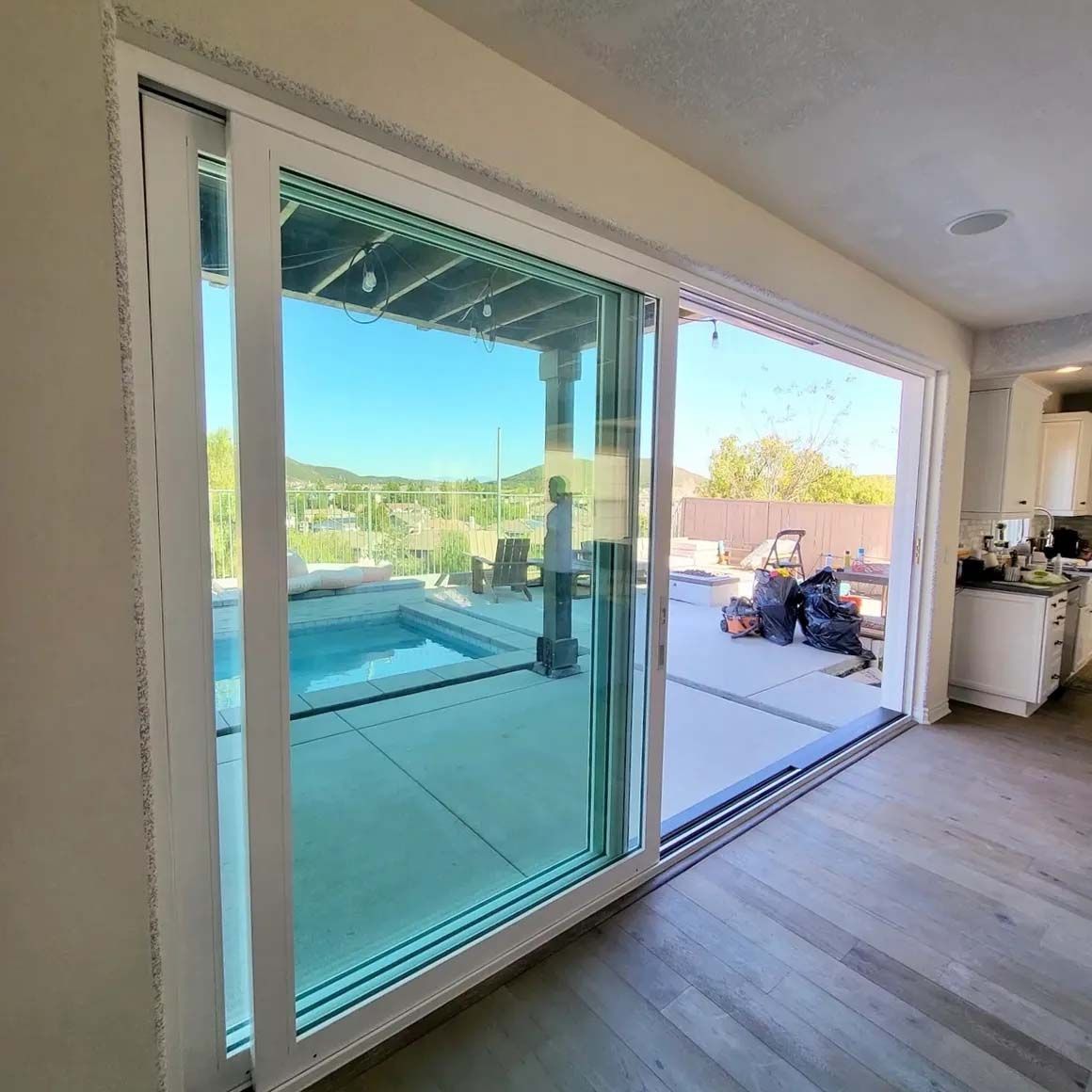 A large sliding glass door with a view of a pool.