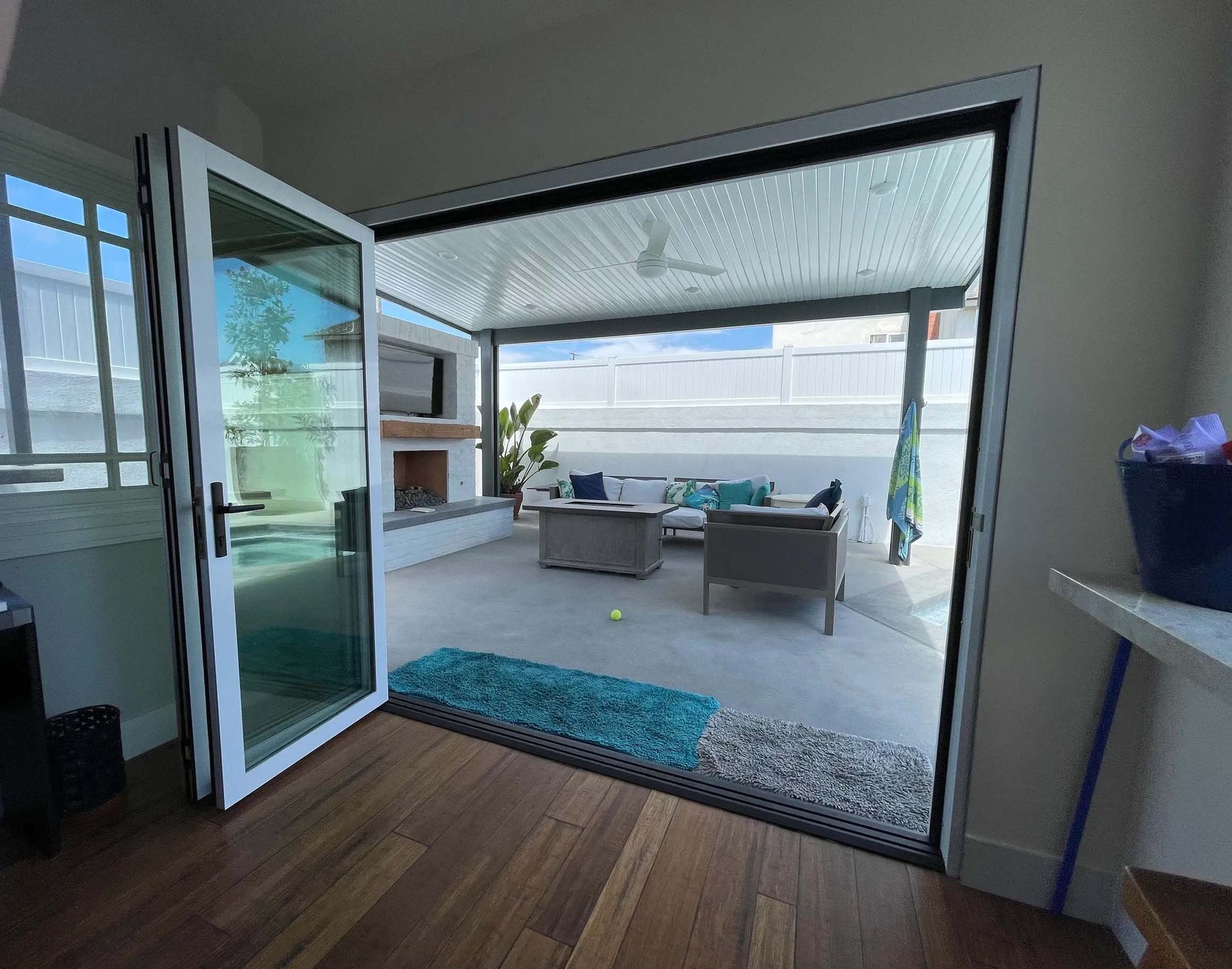 A room with a sliding glass door leading to a patio with furniture and a fireplace.
