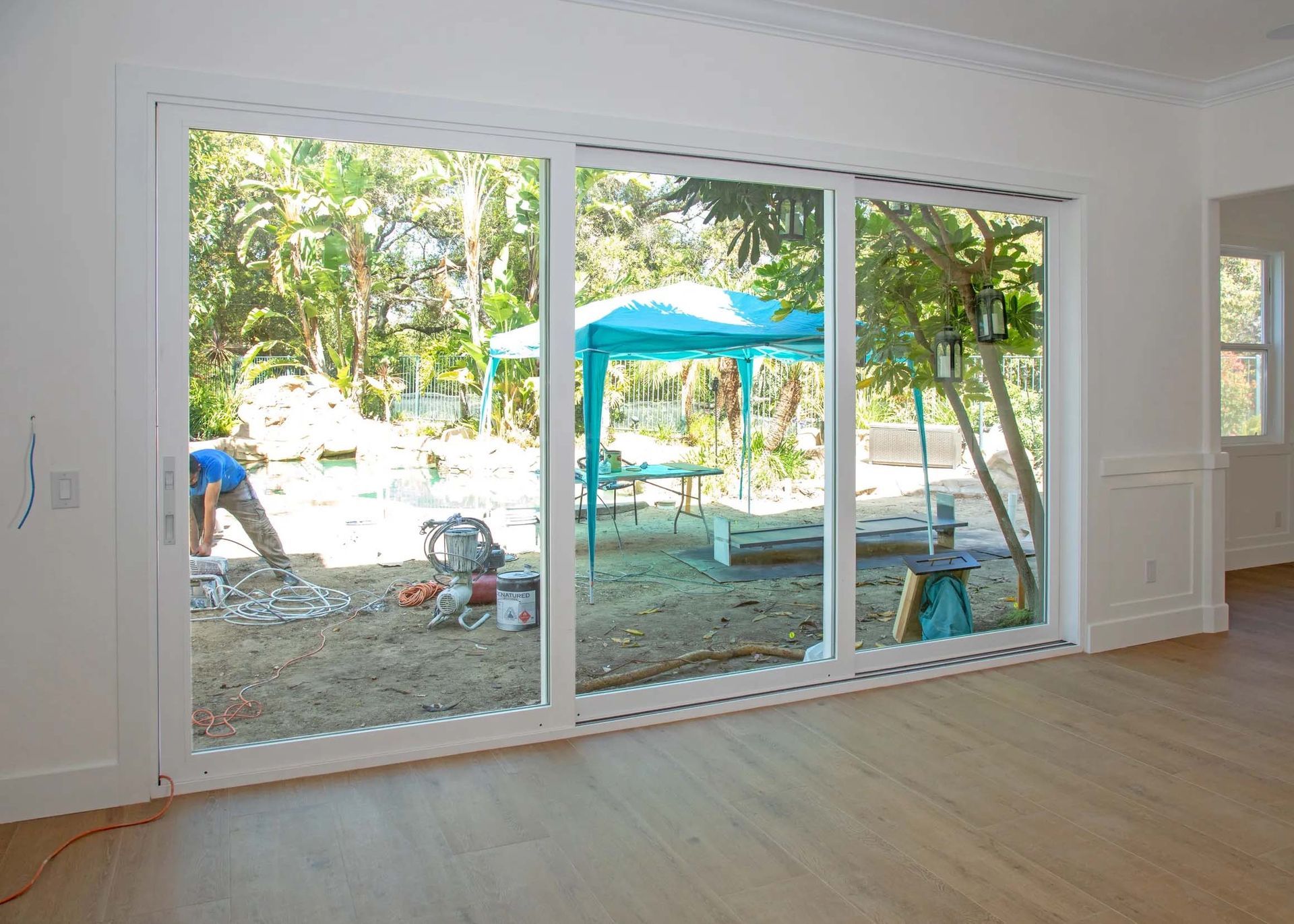 An empty room with a sliding glass door leading to a backyard.