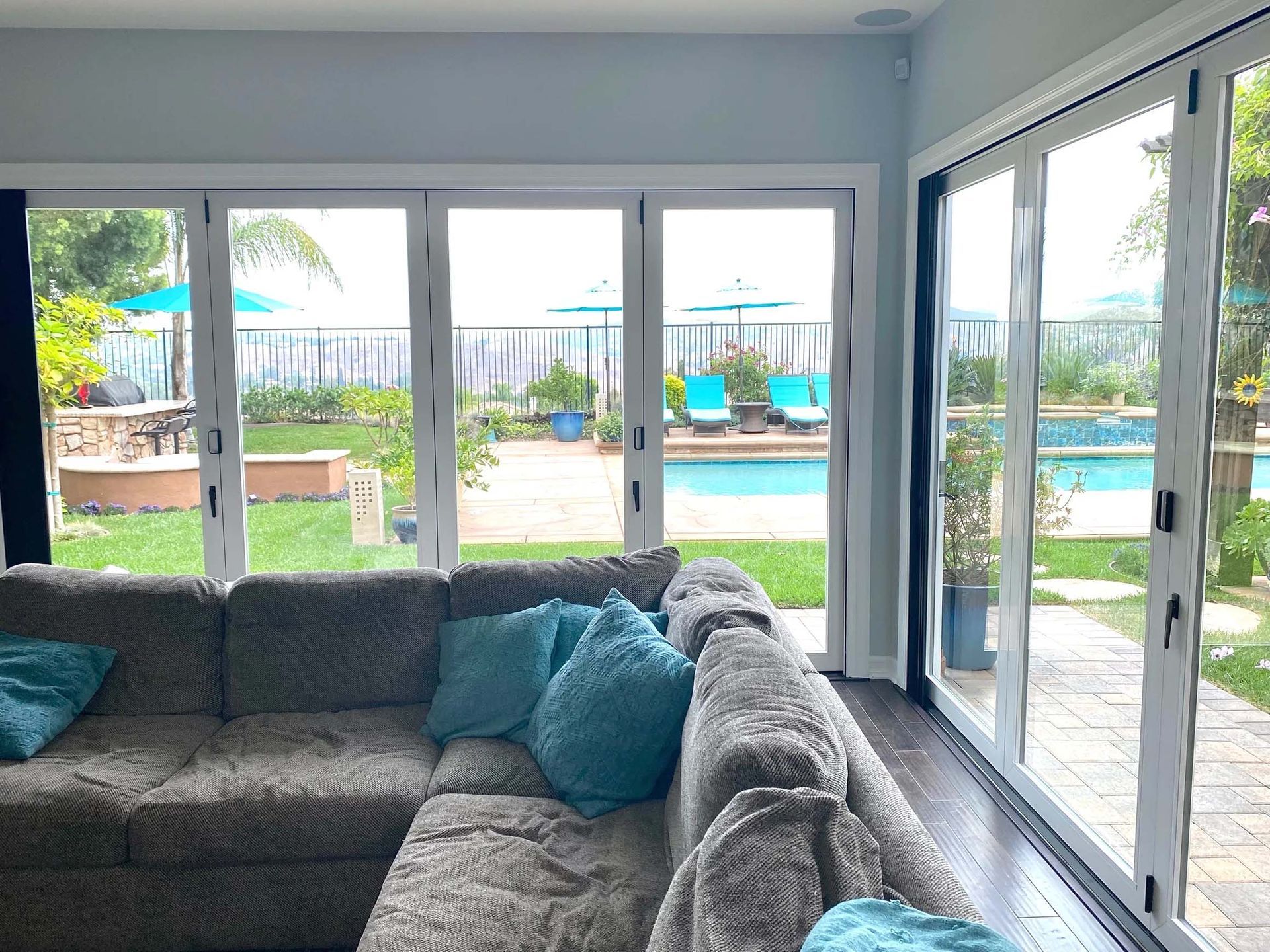 A living room with a couch and sliding glass doors leading to a pool.