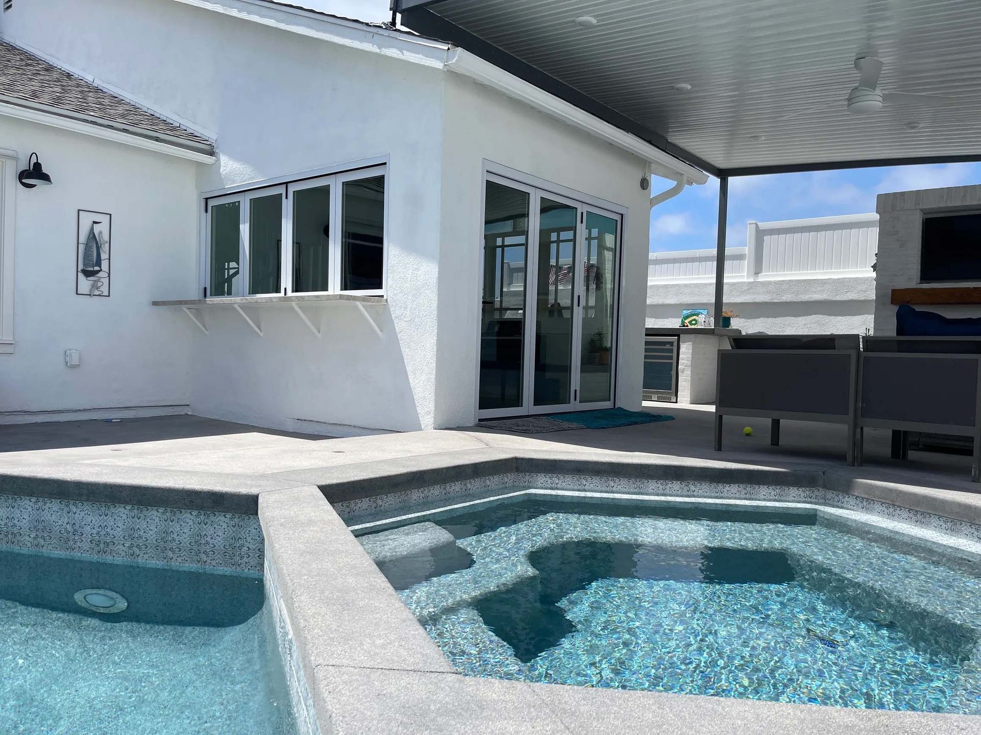 There is a swimming pool in the backyard of a house.