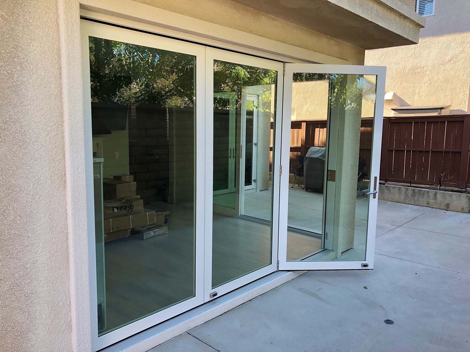 A white sliding glass door is open to a patio.