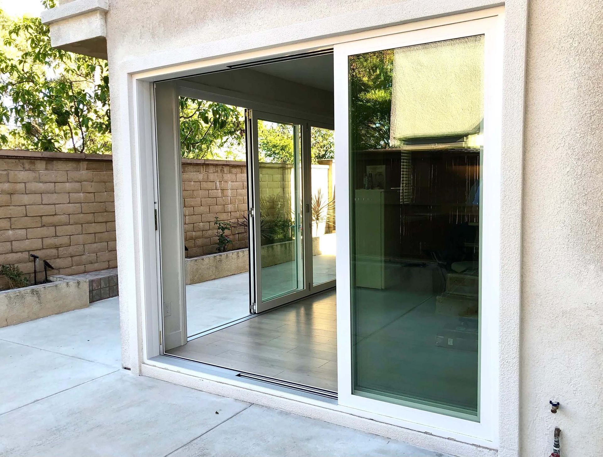 A white sliding glass door is open to a patio.