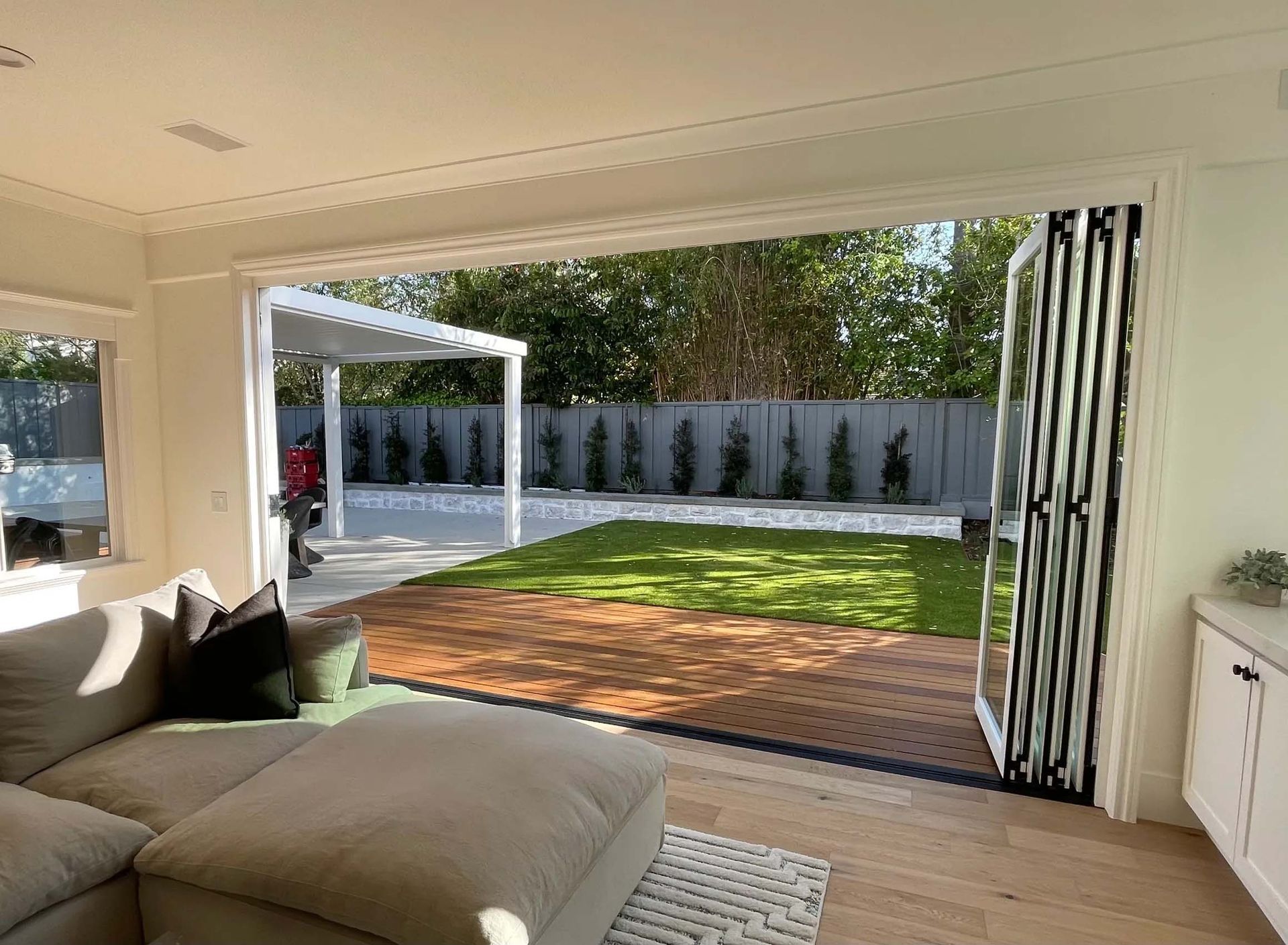 A living room with a couch and sliding glass doors leading to a backyard.