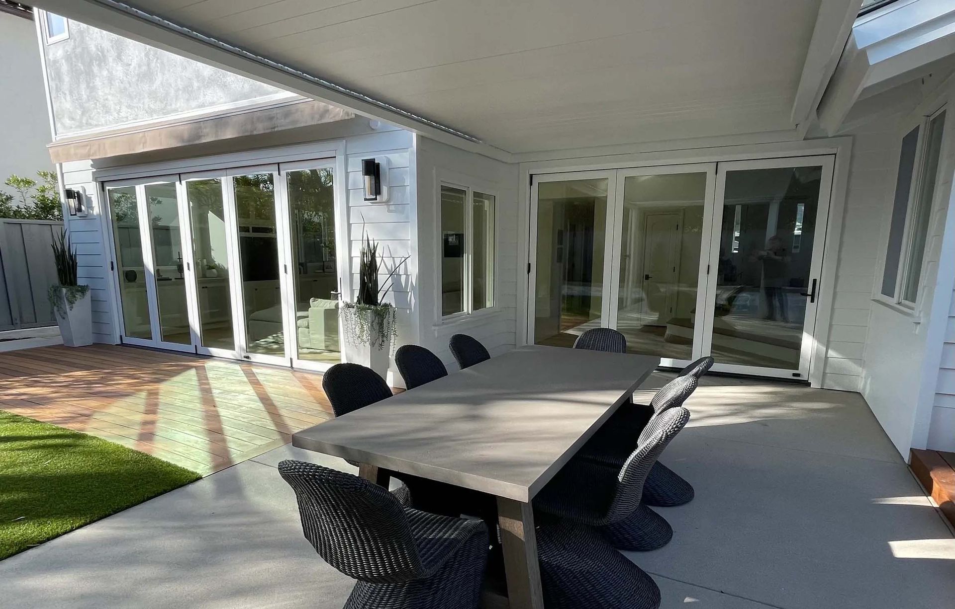 There is a table and chairs on the patio of a house.