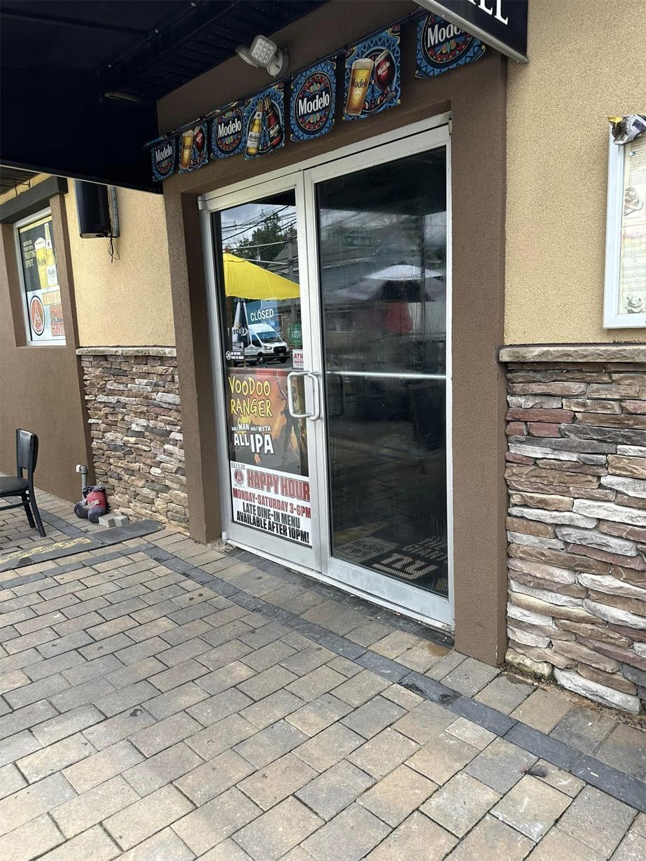 Storefront entrance with glass doors and stone facade under an awning