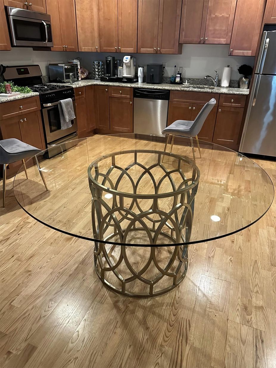 Glass-top table with woven base in a kitchen with wooden cabinets and stainless appliances