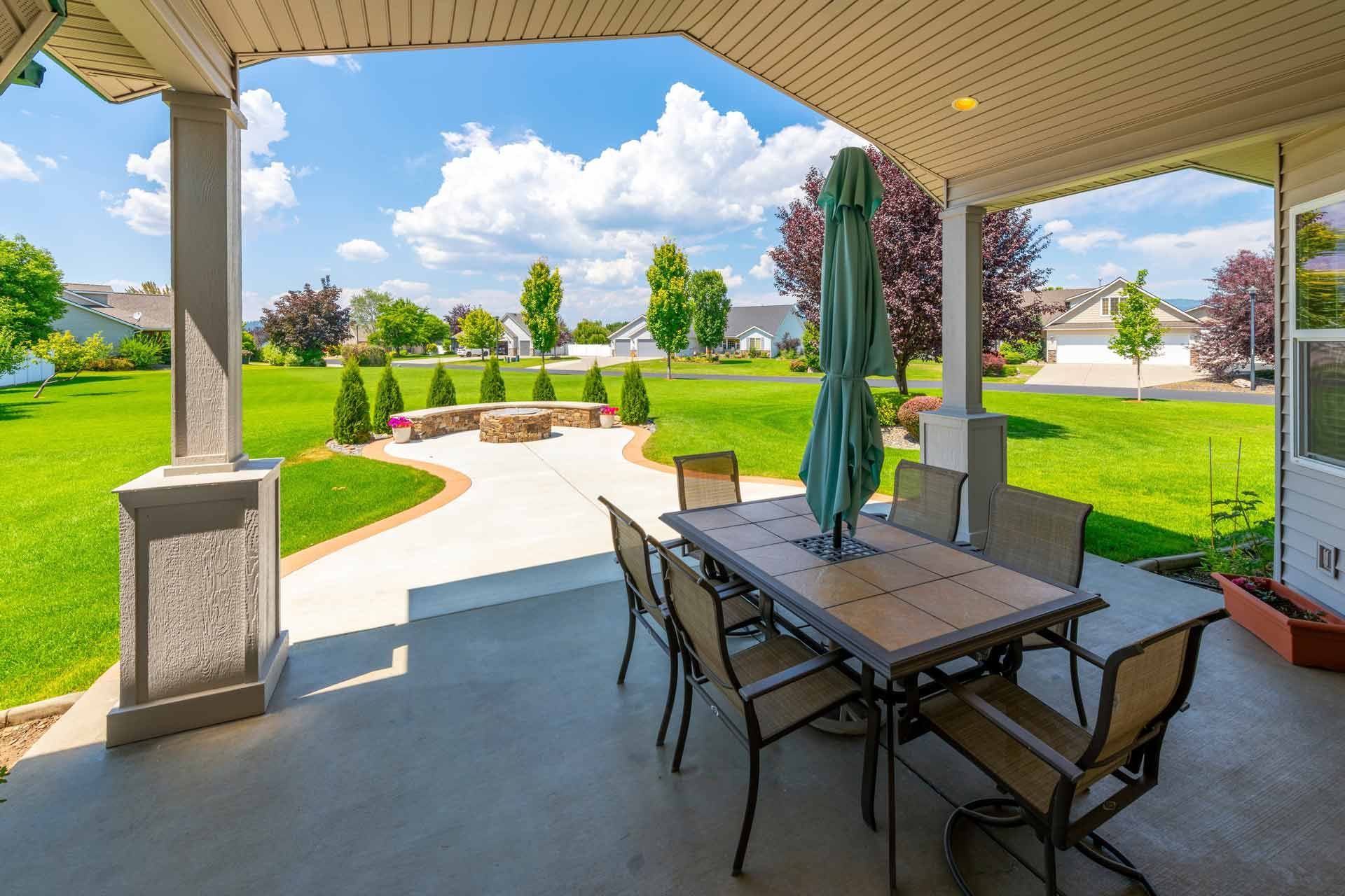 A patio with a table and chairs and an umbrella