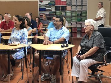 a group of people are sitting at desks in a classroom .