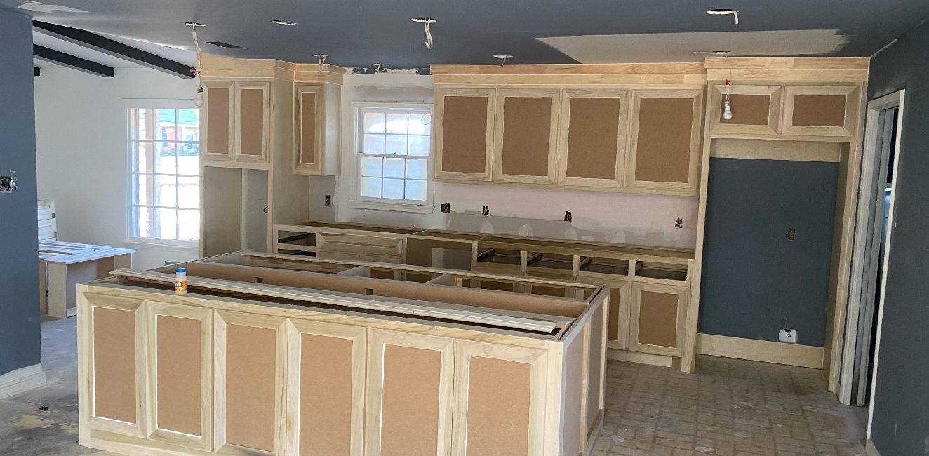 Kitchen cabinets under construction, with an island and countertop in a new home.