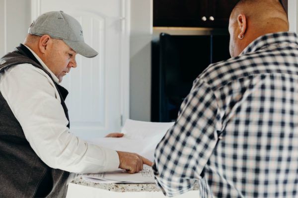 Two people reviewing papers at a kitchen counter in a modern home