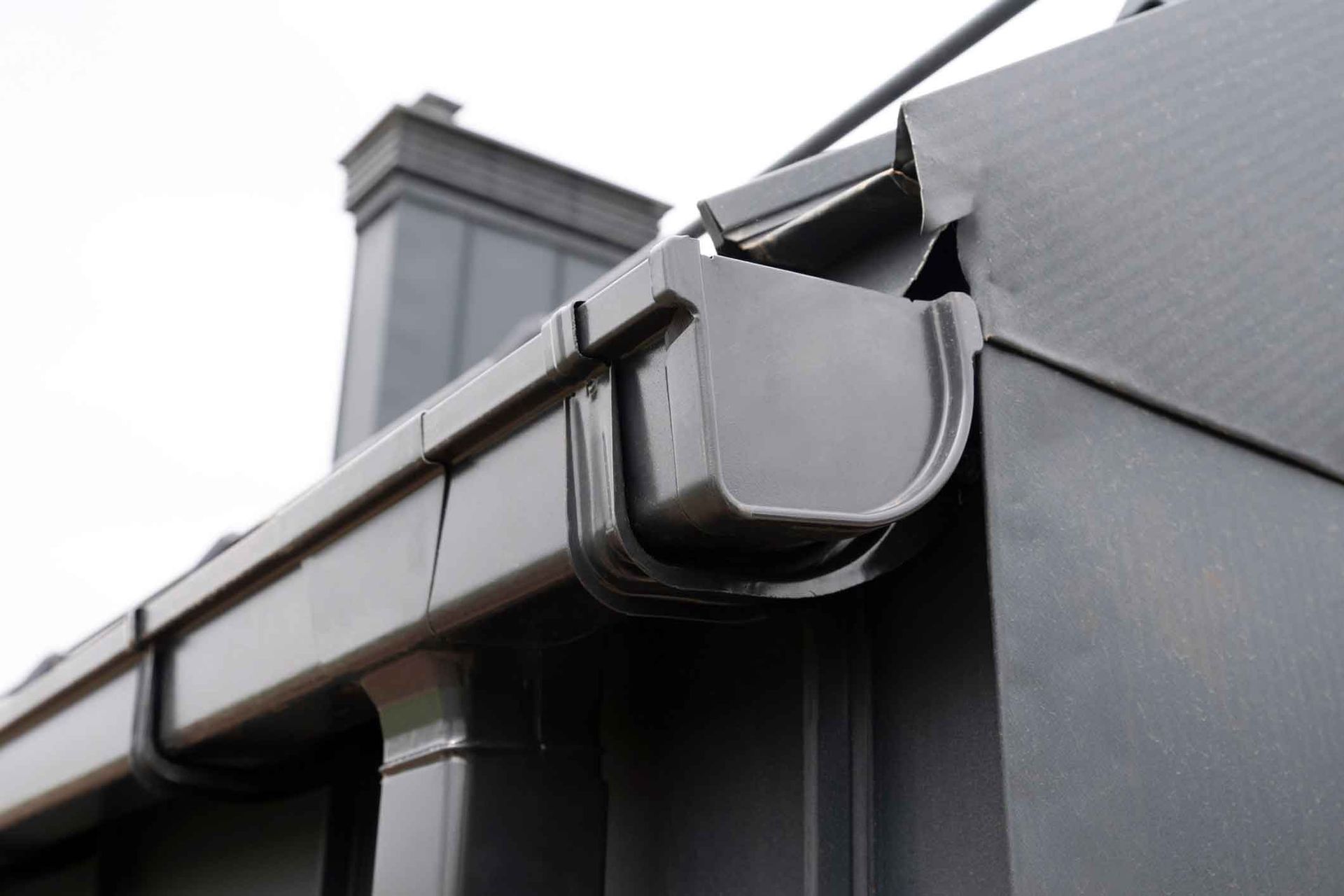 A close up of a gutter on the side of a building