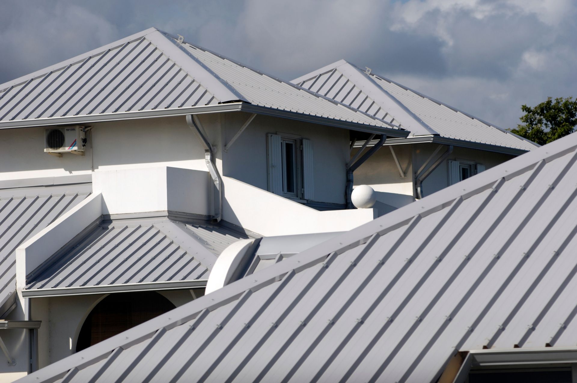 A white house with a gray metal roof