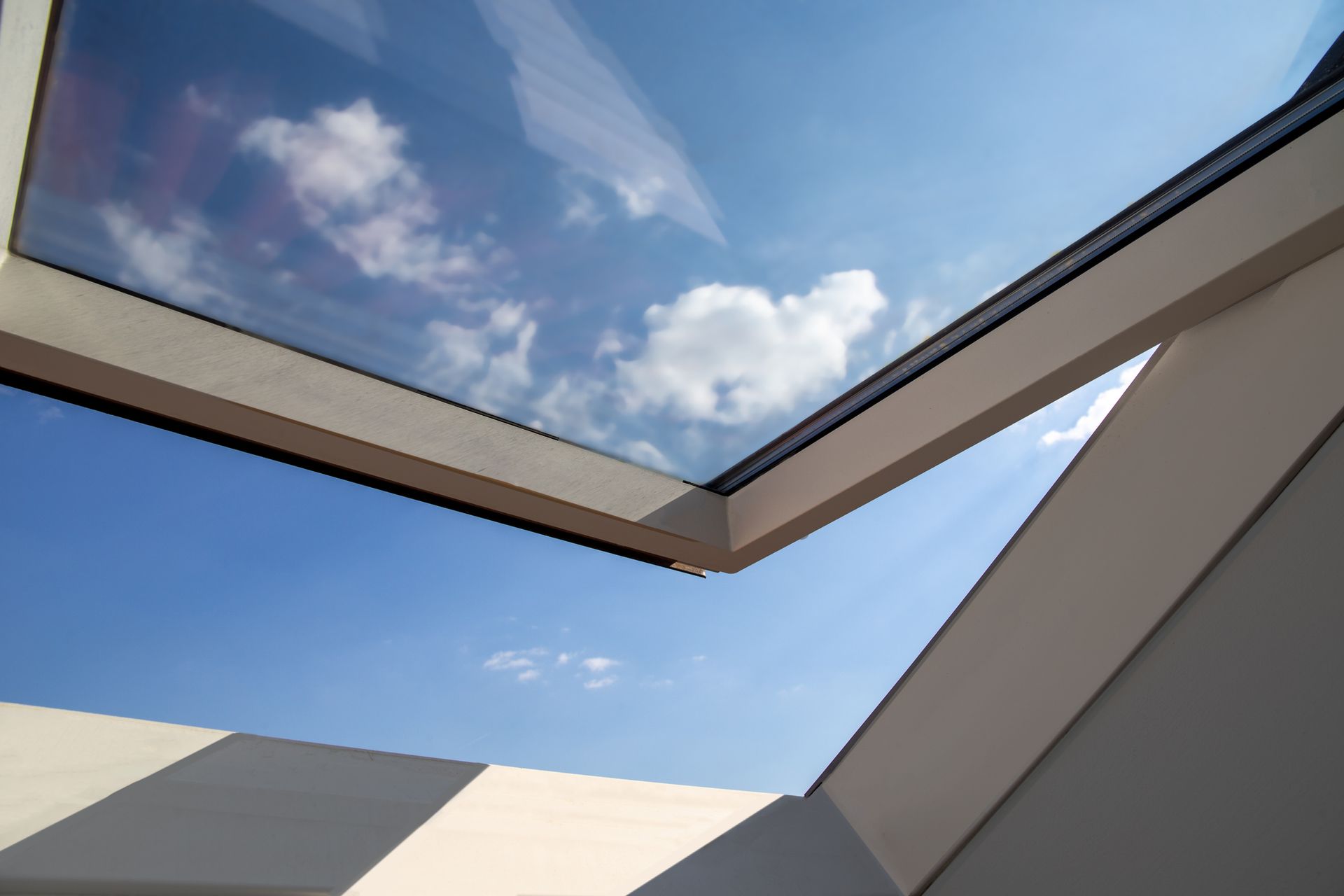 Looking through a skylight at a blue sky with clouds