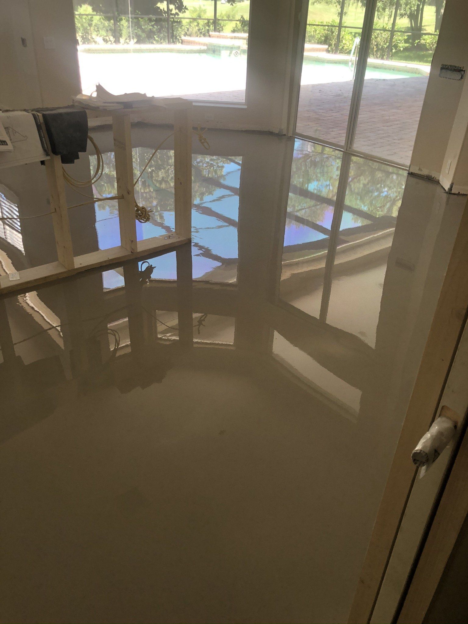 Indoor flooded lobby with reflections of windows and doors on water-covered floor