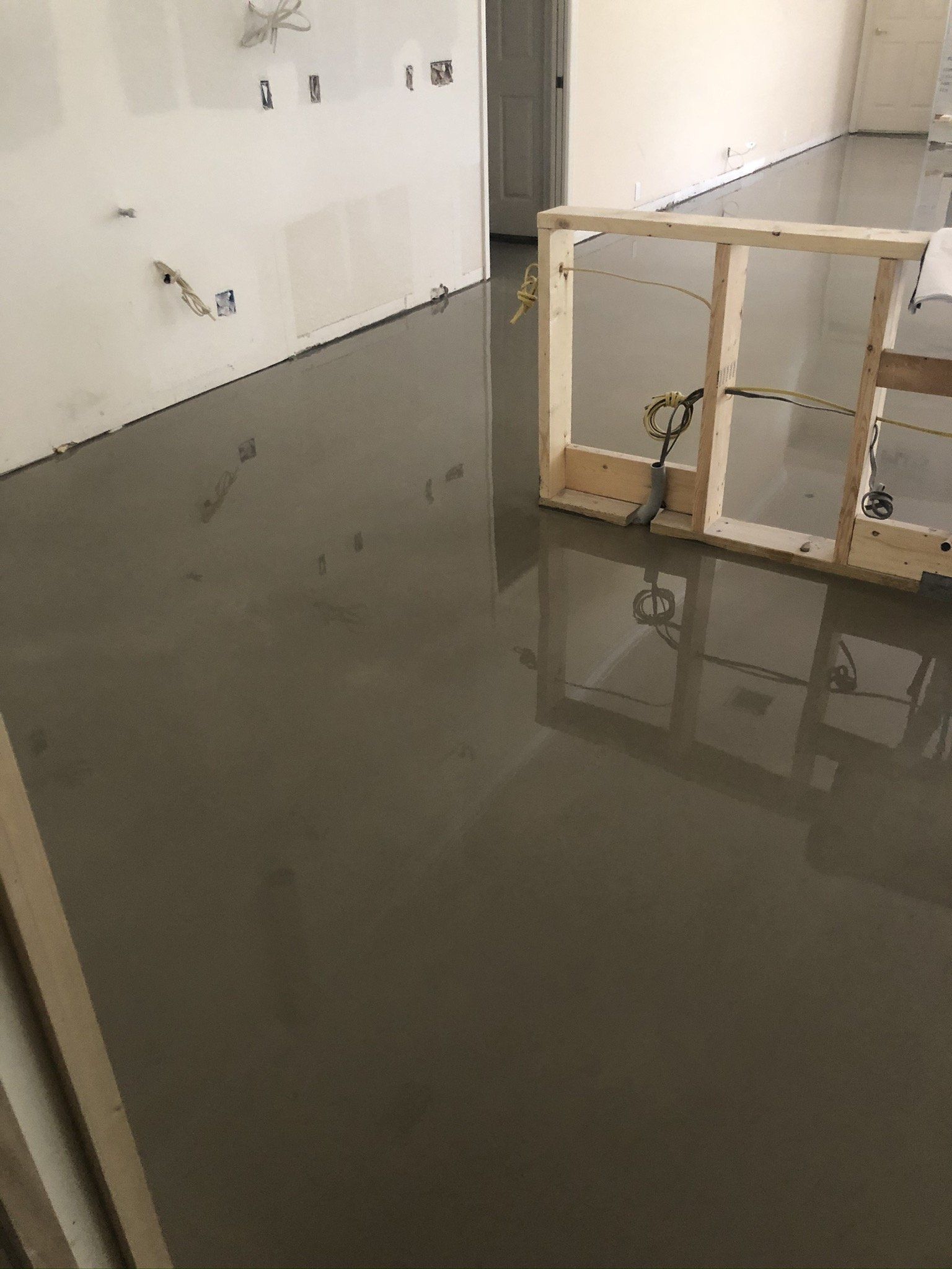Flooded indoor room with standing water, white walls, and a wooden crate partially submerged.