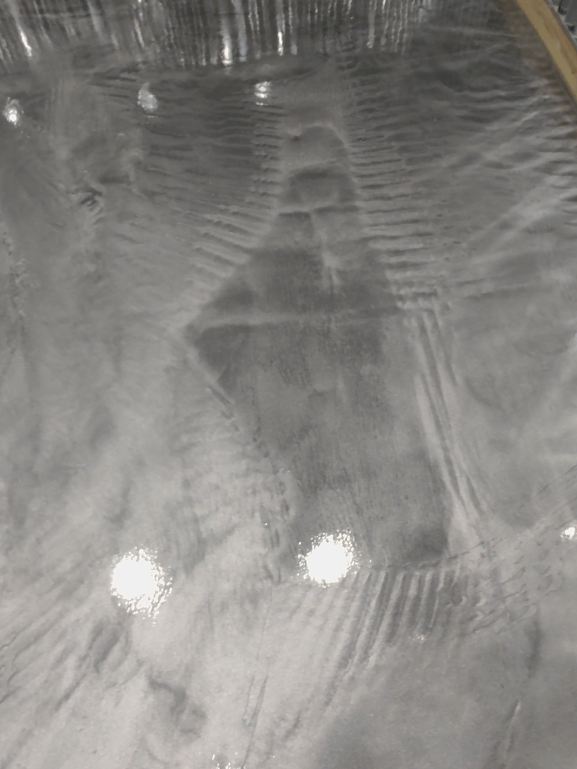 Blurred gray abstract surface with two bright light reflections and wavy texture