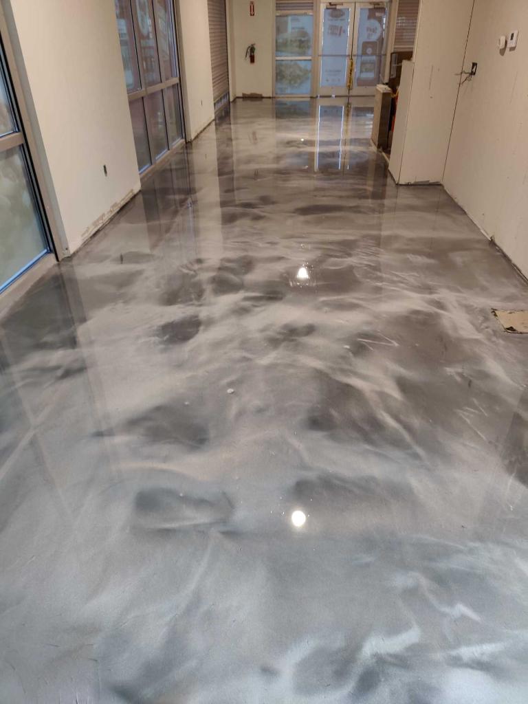 Polished gray marble hallway floor with reflections in a bright indoor corridor