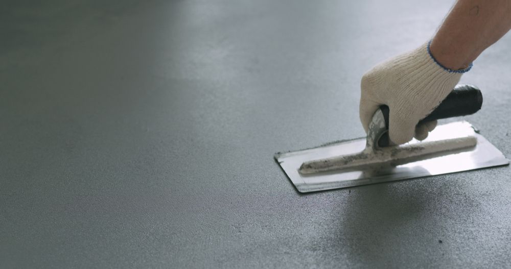 A Person is Using a Trowel on a Concrete Floor — Tiger Concrete ACT In Fadden, ACT