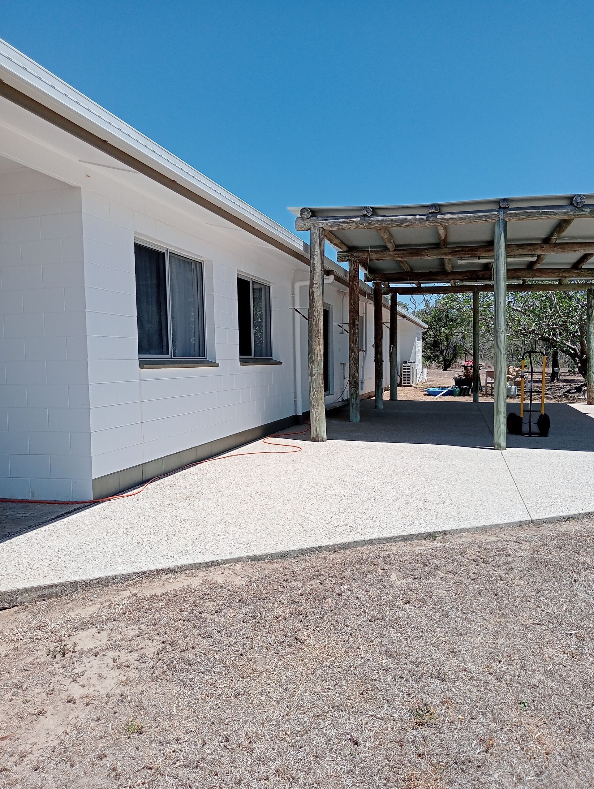 White Building With Windows and a Wooden Carport Under a Blue Sky — All Sparkles Cleaning Technology In Home Hill, QLD