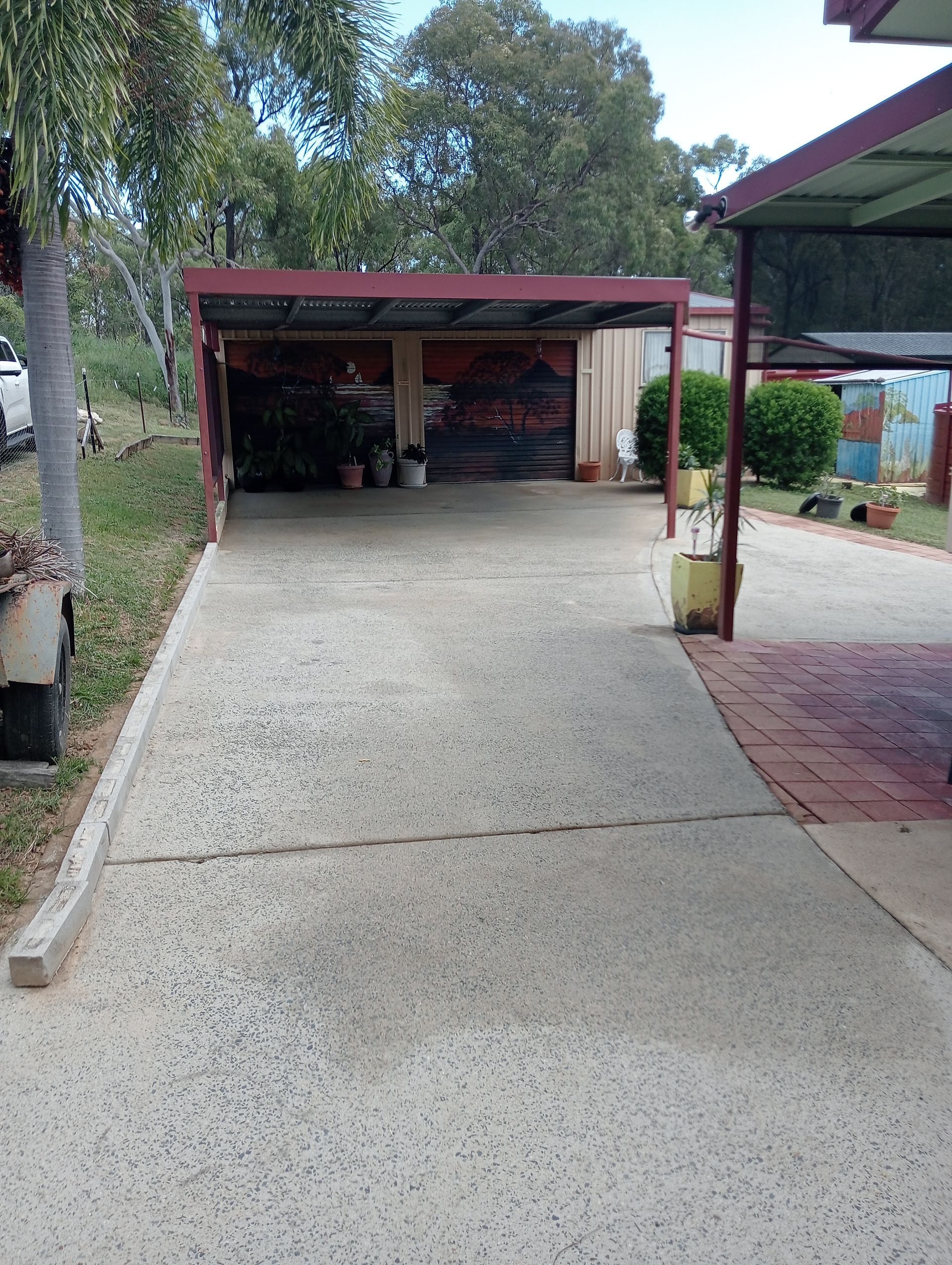 Concrete Driveway Leading to a Carport With a Red Metal Roof — All Sparkles Cleaning Technology In Airlie Beach, QLD