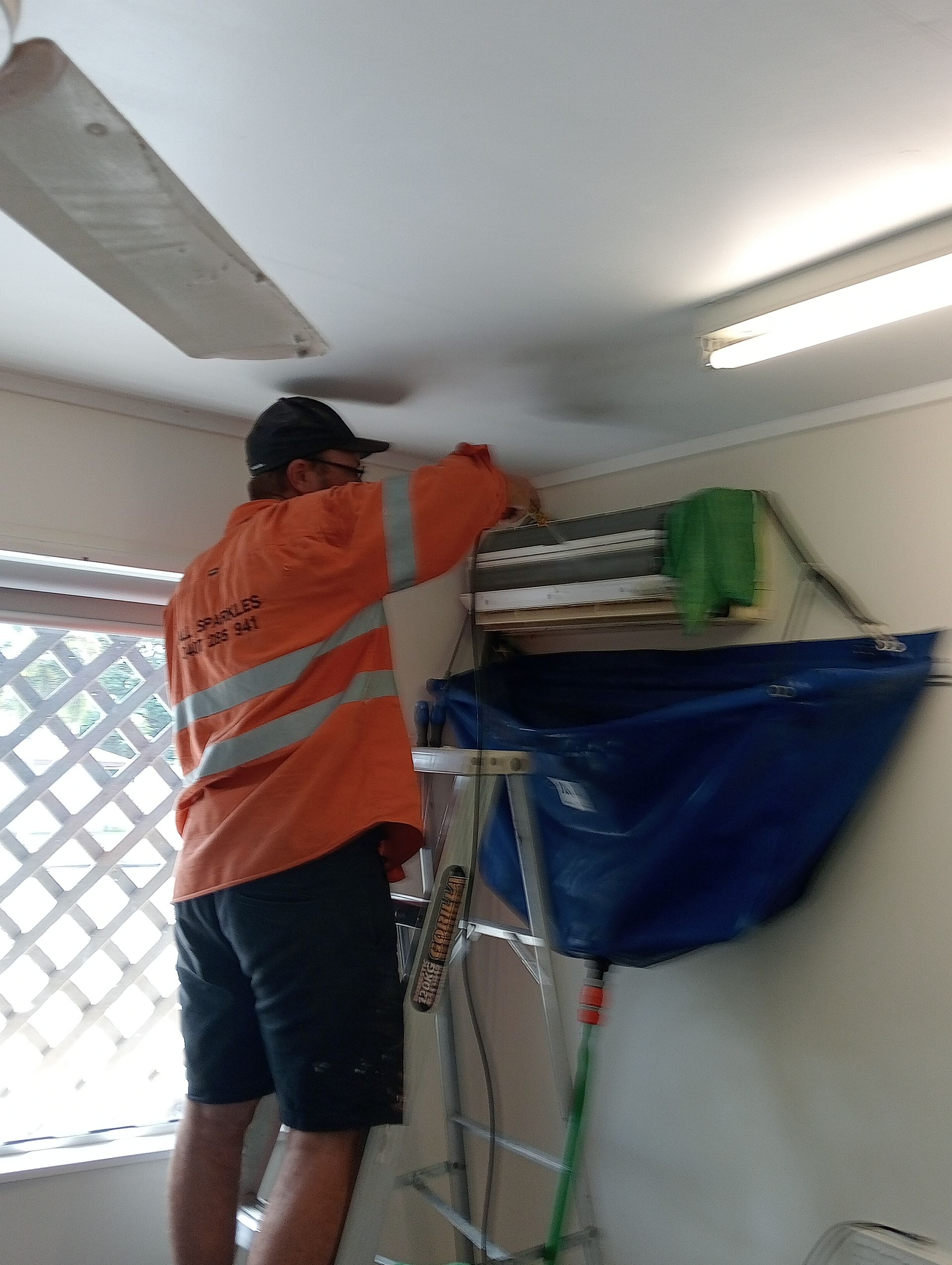 Man in Orange Vest, on a Ladder — All Sparkles Cleaning Technology In Airlie Beach, QLD