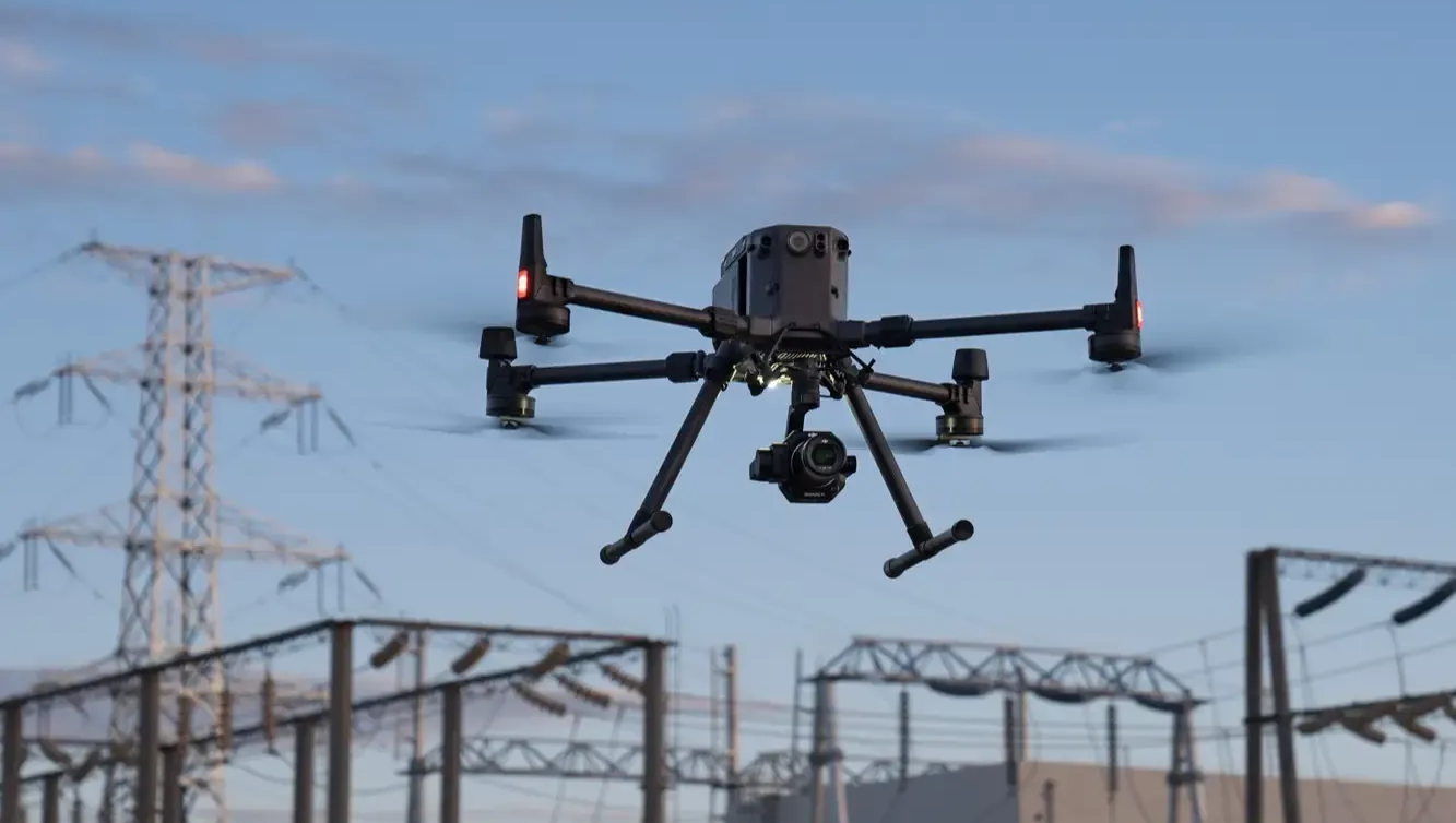 A drone carrying a package flies over a blue map. Text reads: