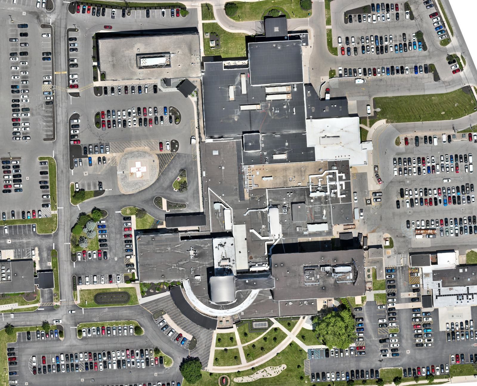 Drone orthomosaic map of a large medical campus in Columbus, Ohio, showing roofs, rooftop equipment, a helipad and surrounding parking lots with every vehicle visible