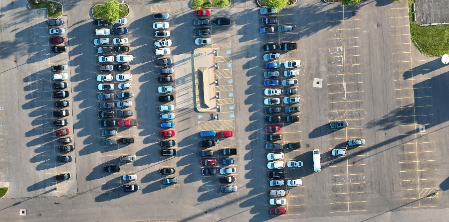 Shuttle lot at 7 a.m., about half full with long morning shadows
