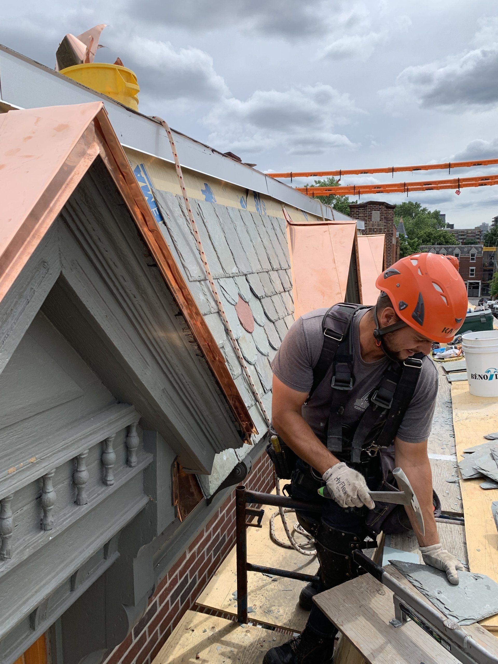 Un homme travaille sur le toit d'un immeuble.