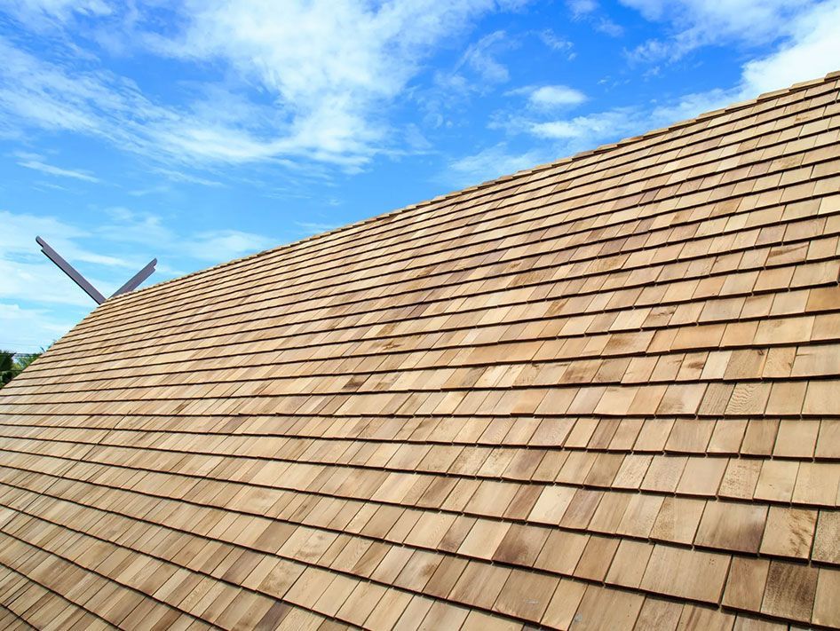 Un gros plan d'un toit en bois avec un ciel bleu en arrière-plan.